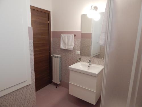 een badkamer met een wastafel en een spiegel bij Canale rooms e apartments in Casteldaccia