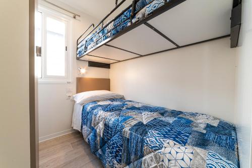 a bedroom with a bed and a bunk ladder at Camping Village Cavallino in Cavallino-Treporti