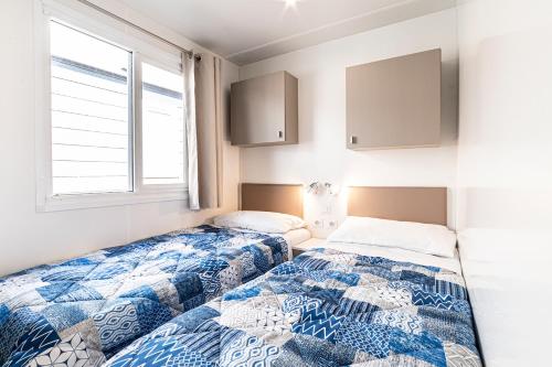two beds sitting next to each other in a bedroom at Camping Village Cavallino in Cavallino-Treporti