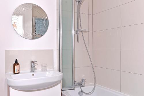 a bathroom with a shower and a sink and a mirror at Pevensey Beach Retreat in Pevensey