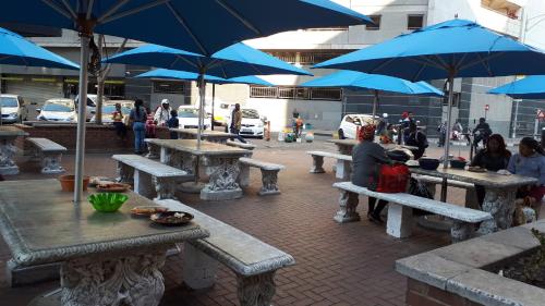 a group of picnic tables with blue umbrellas at 4 on Pritchard Luxury Suites in Johannesburg