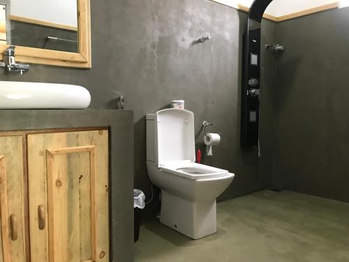 ein Badezimmer mit einem weißen WC und einem Waschbecken in der Unterkunft Rawana View Ella in Ella