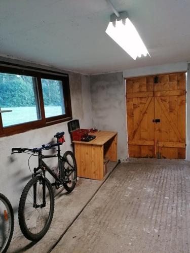 a bike parked in a room with a desk at Gîte des Planches Le Pit in Saint-Bresson