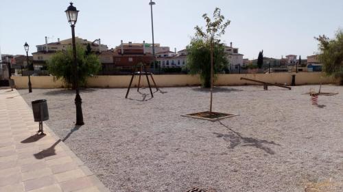 um parque com duas árvores e um baloiço em Apartamento Pergar II Alojamiento para empresas-WIFI 4 Personas em Las Gabias
