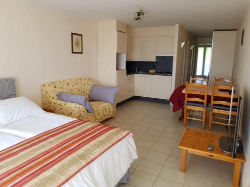 ヴィラール・シュル・オロンにあるRoute du Village 5 Residence Panoramaのベッドルーム1室(ベッド1台、ソファ、テーブル付)