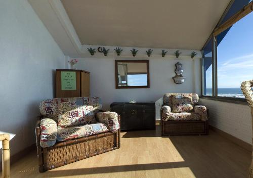 a living room with two chairs and a window at LOFT OIA - ES UNA FILOSOFIA DE VIDa in Oia