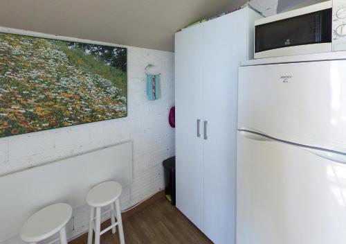 a kitchen with a refrigerator and two stools at LOFT OIA - ES UNA FILOSOFIA DE VIDa in Oia