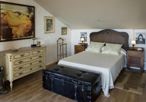 a bedroom with a large bed and a dresser at LOFT OIA - ES UNA FILOSOFIA DE VIDa in Oia