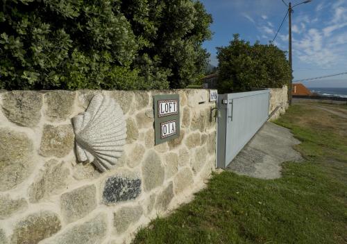 a stone wall with a no parking sign and a gate at LOFT OIA - ES UNA FILOSOFIA DE VIDa in Oia