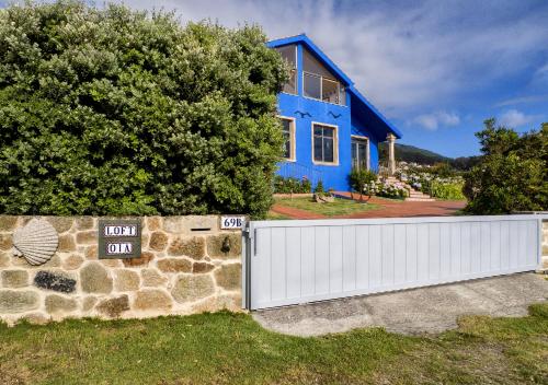 a blue house with a fence in front of it at LOFT OIA - ES UNA FILOSOFIA DE VIDa in Oia