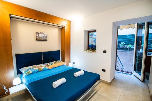 Cama azul en habitación con ventana en La Stella di Chiaia, en Nápoles