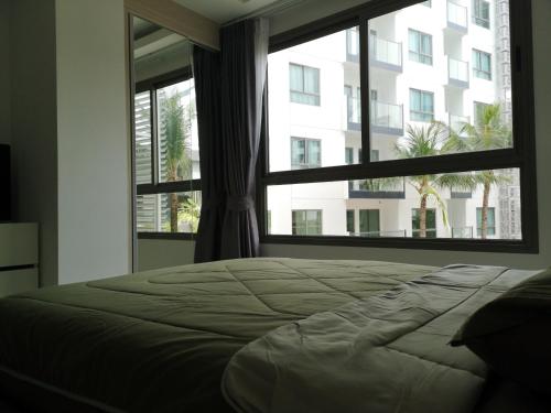 um quarto com uma cama e uma janela grande em 2BDR in Water Resort close to WalkingStreet em Pattaya Sul