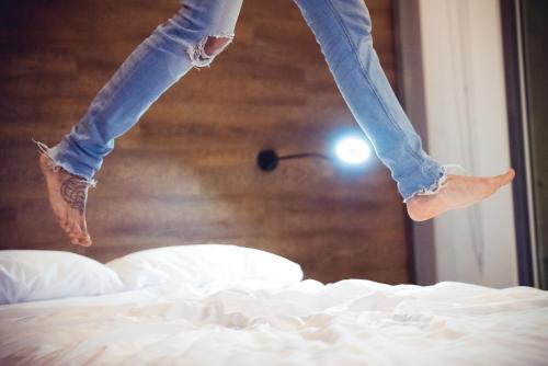 a person jumping on top of a bed at Hotel Spirito by Spiwak Chipichape in Cali