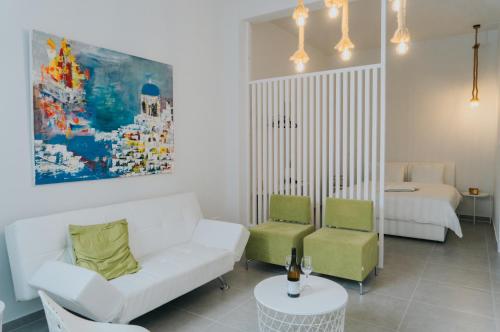 a living room with a white couch and green chairs at Prima Gardens City Studios in Larnaka
