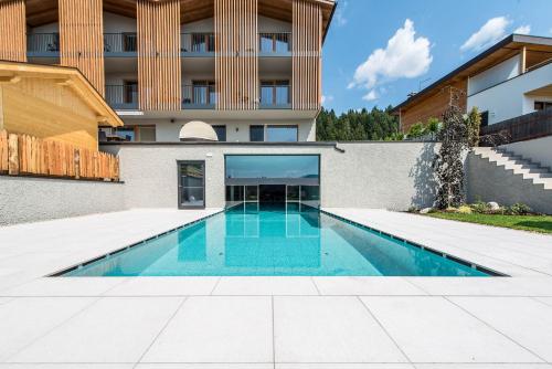 a swimming pool in front of a building at Hotel Sonnenheim in Chienes