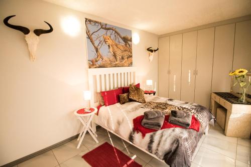 ein Schlafzimmer mit einem Bett und einem Wandgemälde in der Unterkunft John-Lou's One-bedroom Apartment in Windhoek