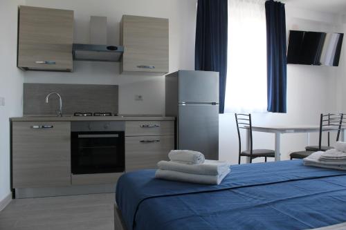 a kitchen with a bed with towels on it at Naxos Laguna Beach in Giardini Naxos