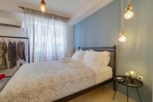 una camera da letto con un letto con lenzuola bianche e una finestra di Stylish, Comfy Suite in the Heart of Athens ad Atene
