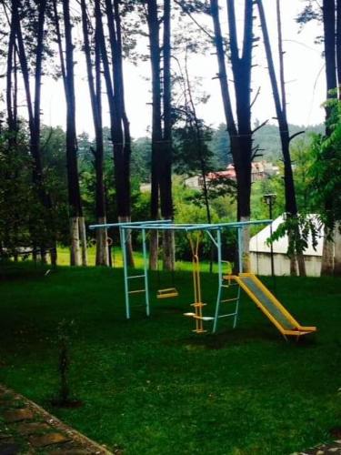 a playground in a yard with trees at Hotel Jardin Rincon de las Estrellas in Velasco