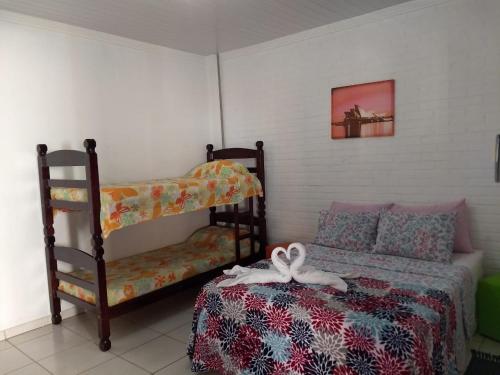 a bedroom with a bed and a bunk bed and a shelf at Pousada & Pesca Esportiva Fazolin in Socorro