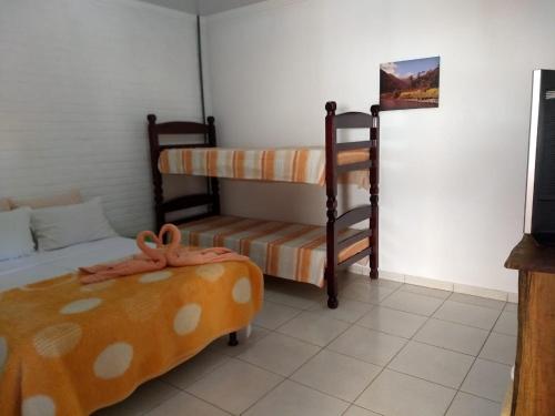 a room with two bunk beds and a couch at Pousada & Pesca Esportiva Fazolin in Socorro