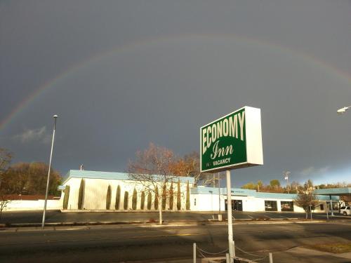 a street sign in front of a building with a rainbow in the sky at Economy Inn Paso Robles in Paso Robles