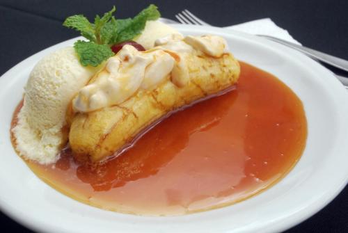 a white plate with a dessert with ice cream and sauce at Hotel Pousada do Arcanjo in Ouro Preto