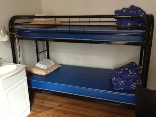 a room with two bunk beds with blue sheets at Auberge Jeunesse La Belle Planete Backpackers Hostel in Quebec City