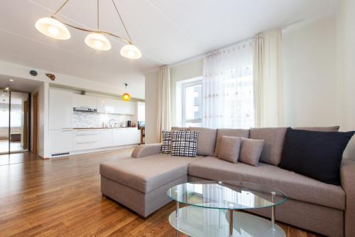 ein Wohnzimmer mit einem Sofa und einem Glastisch in der Unterkunft City Center Apartment - Mardi st., FREE Parking!!! in Tallinn
