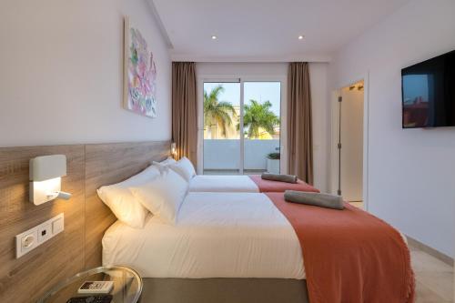 Villa Deluxe Suites Maspalomas tesisinde bir odada yatak veya yataklar