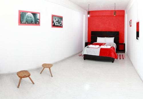 a bedroom with a bed and a red wall at Hotel Boutique Otomi cerca de Tolantongo in Cardonal