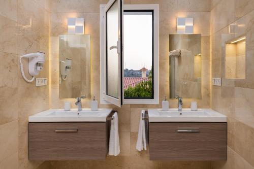 a bathroom with two sinks and a window at Villa Deluxe Suites Maspalomas in Maspalomas