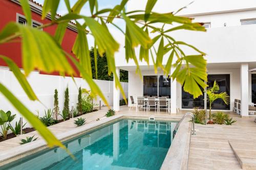 a swimming pool in front of a house at Villa Deluxe Suites Maspalomas in Maspalomas