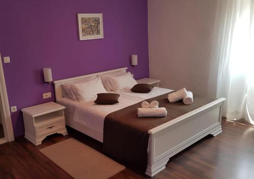 1 dormitorio con 1 cama con pared morada en Casa Ferata - holiday home, en Vižinada