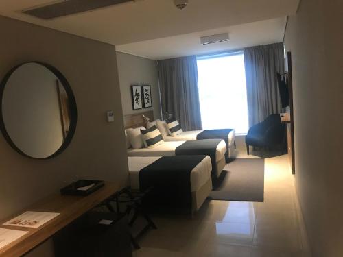 a hotel room with two beds and a mirror at Agua del Corral Hotel & Spa in Mendoza