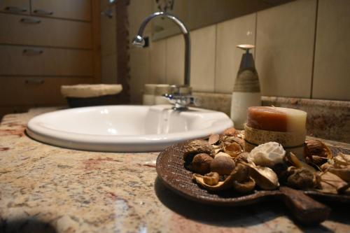 a bathroom counter with a sink and a plate of mushrooms at Modern Villa in Chania in Perivólia