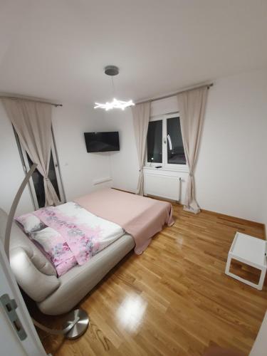 Dormitorio pequeño con cama y TV en Apartman Lux Doboj en Doboj