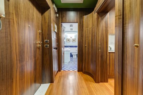 a hallway with wooden walls and a bathroom with a toilet at Pantheon Antique Suite in Rome