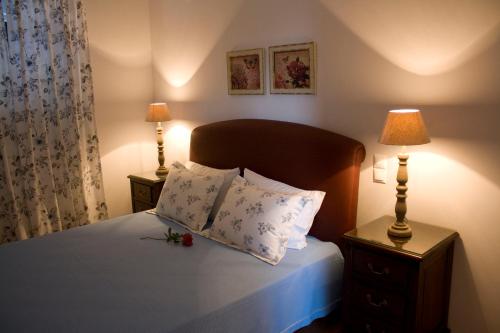a bedroom with a bed with two lamps and two pillows at Anthias Garden in Lefkada Town