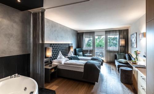 een slaapkamer met een bed en een bad in een kamer bij Hotel Das Stachelburg in Parcines