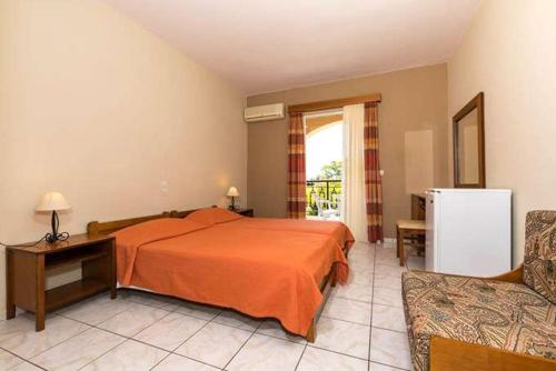 ein Schlafzimmer mit einem Bett, einem Sofa und einem Kühlschrank in der Unterkunft Daniel Hotel in Kalamaki