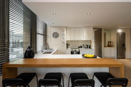 a kitchen with a large island with chairs around it at #1803 Cartwright - Simply Spectacular in Cape Town