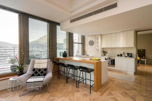 a kitchen with a counter and some chairs in a room at #1803 Cartwright - Simply Spectacular in Cape Town