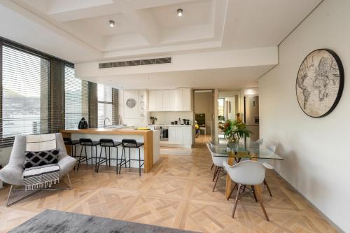 a kitchen and living room with a table and chairs at #1803 Cartwright - Simply Spectacular in Cape Town