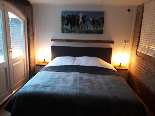a bedroom with a large bed with two lamps on tables at B&B CaSandra in Volendam