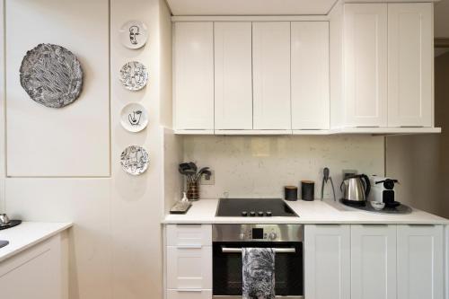 a kitchen with white cabinets and a stove top oven at #1803 Cartwright - Simply Spectacular in Cape Town