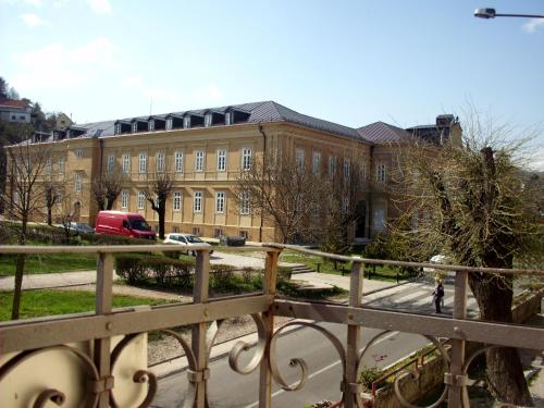 a large brick building with a woman walking in front of it at Apartments Bokan in Cetinje