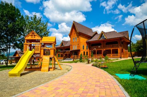a playground with a slide in front of a house at Boyarsky Dvor Inn in Dakhovskaya
