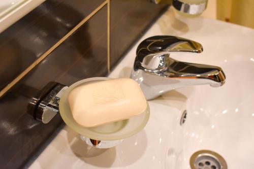 a cup sitting on a sink next to a faucet at Lux Deluxe Apartment in Žabljak