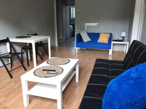 Vanalinna Apartment في تالين: غرفة معيشة مع أريكة زرقاء وطاولة